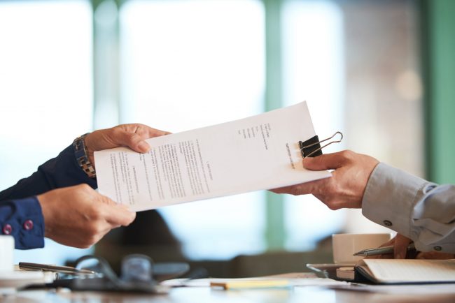 Partnership Man being handed documents illustrates blog "What Is a Restraining Order?"