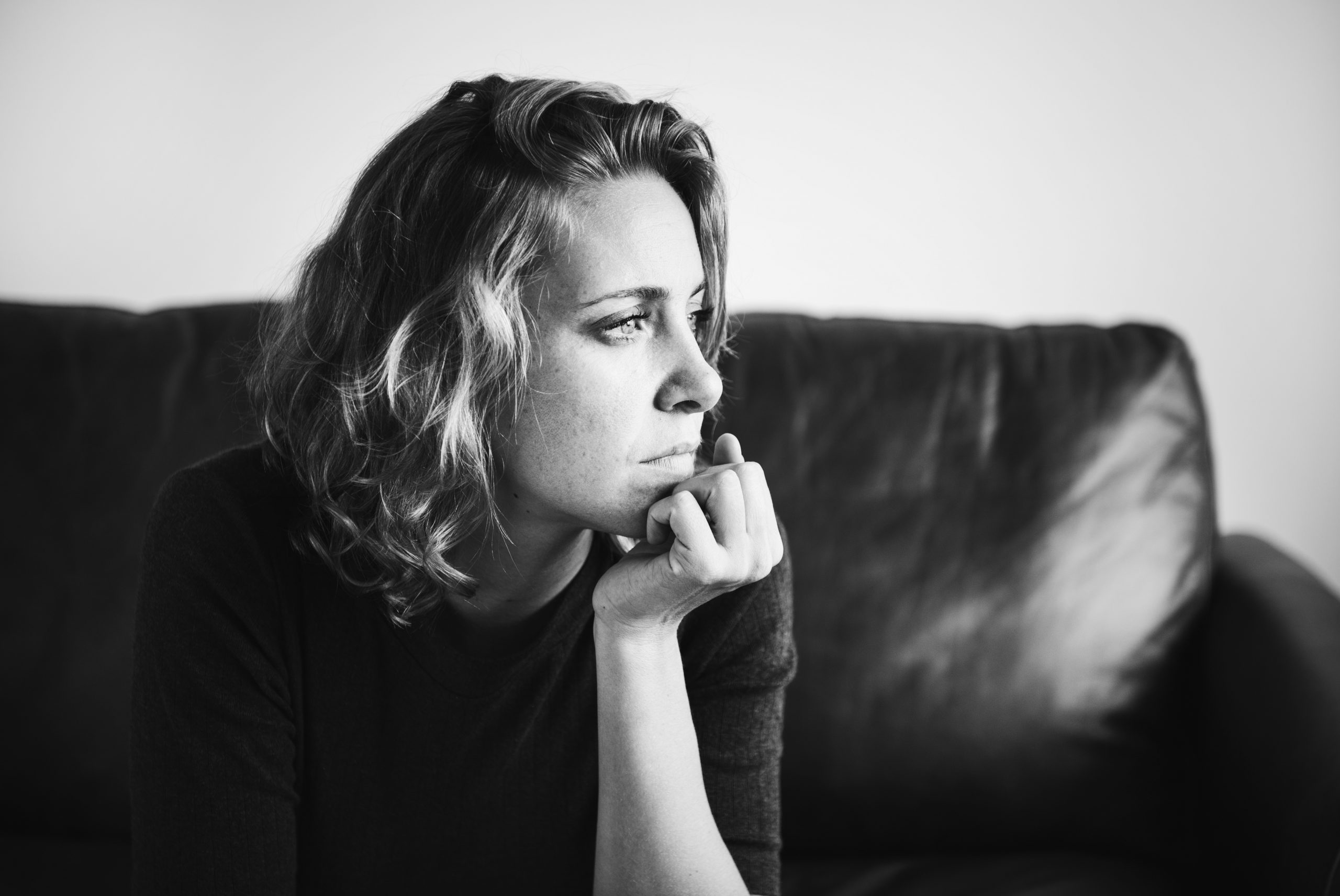 Black-and-white photo of woman gazing into the distance illustrate blog "What Are Some Signs of Domestic Abuse?"