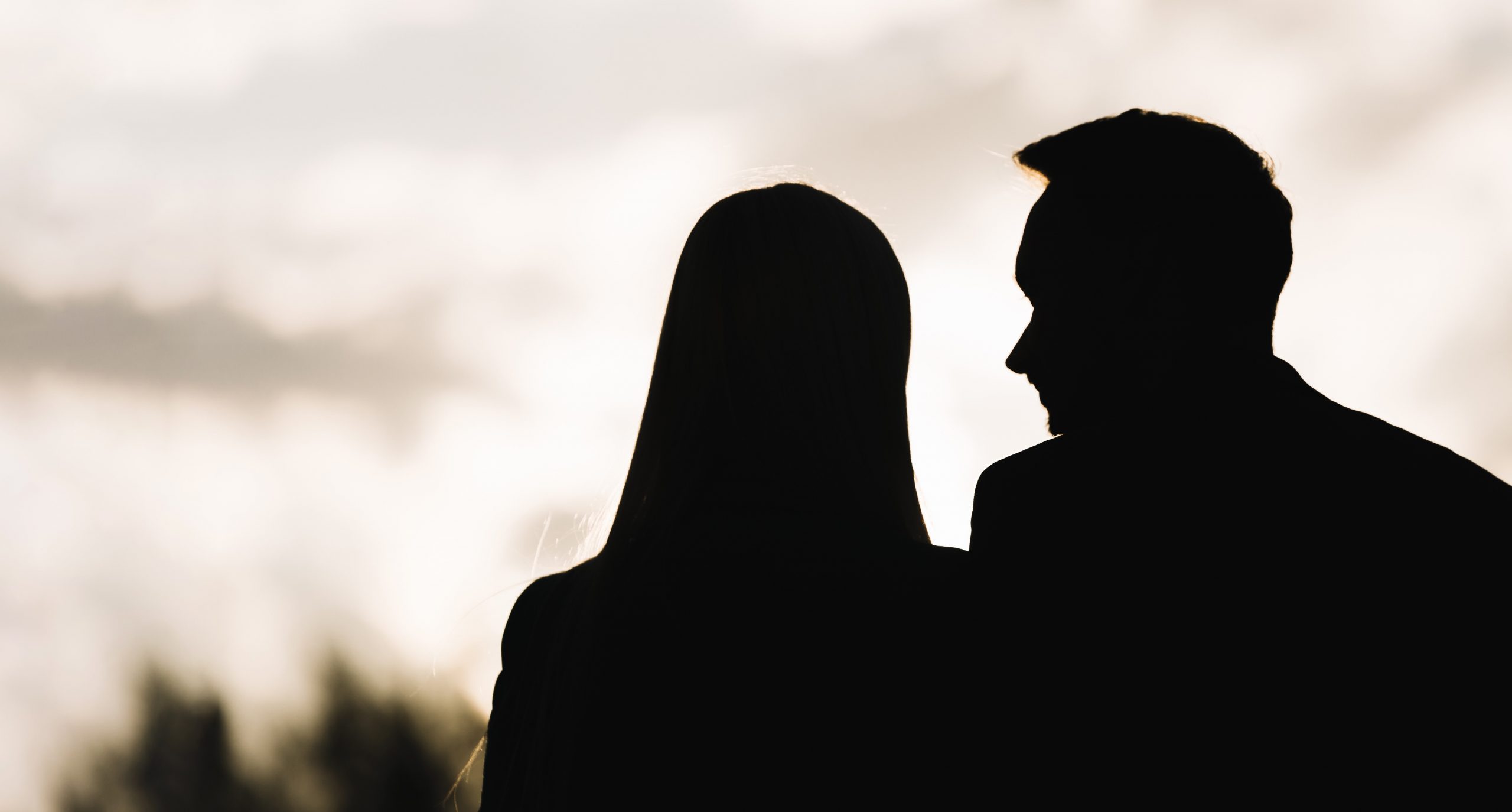 Silhouettes of man and woman on date.