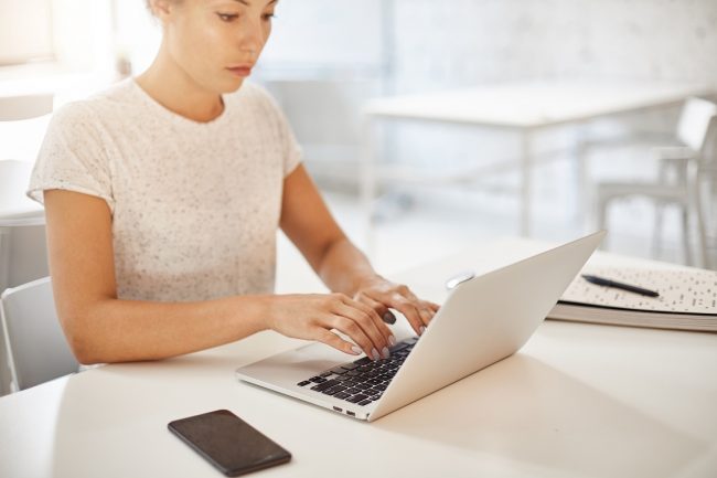 Woman using laptop illustrates blog "The Importance of Raising Awareness About Domestic Violence"