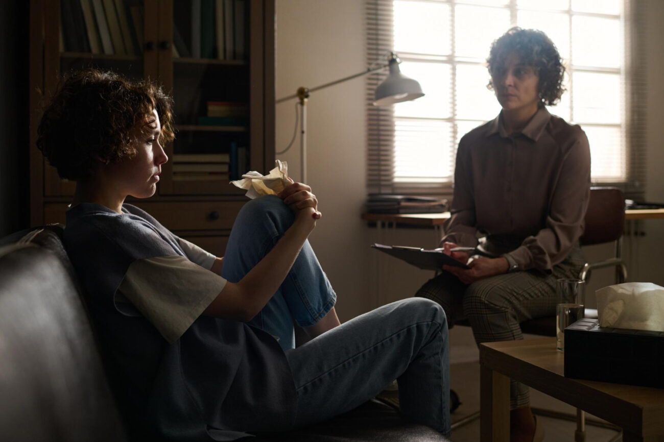 image-young-troubled-woman-sitting-couch-front-psychotherapist Advocate listening compassionately as a survivor talks about why they may minimize abuse